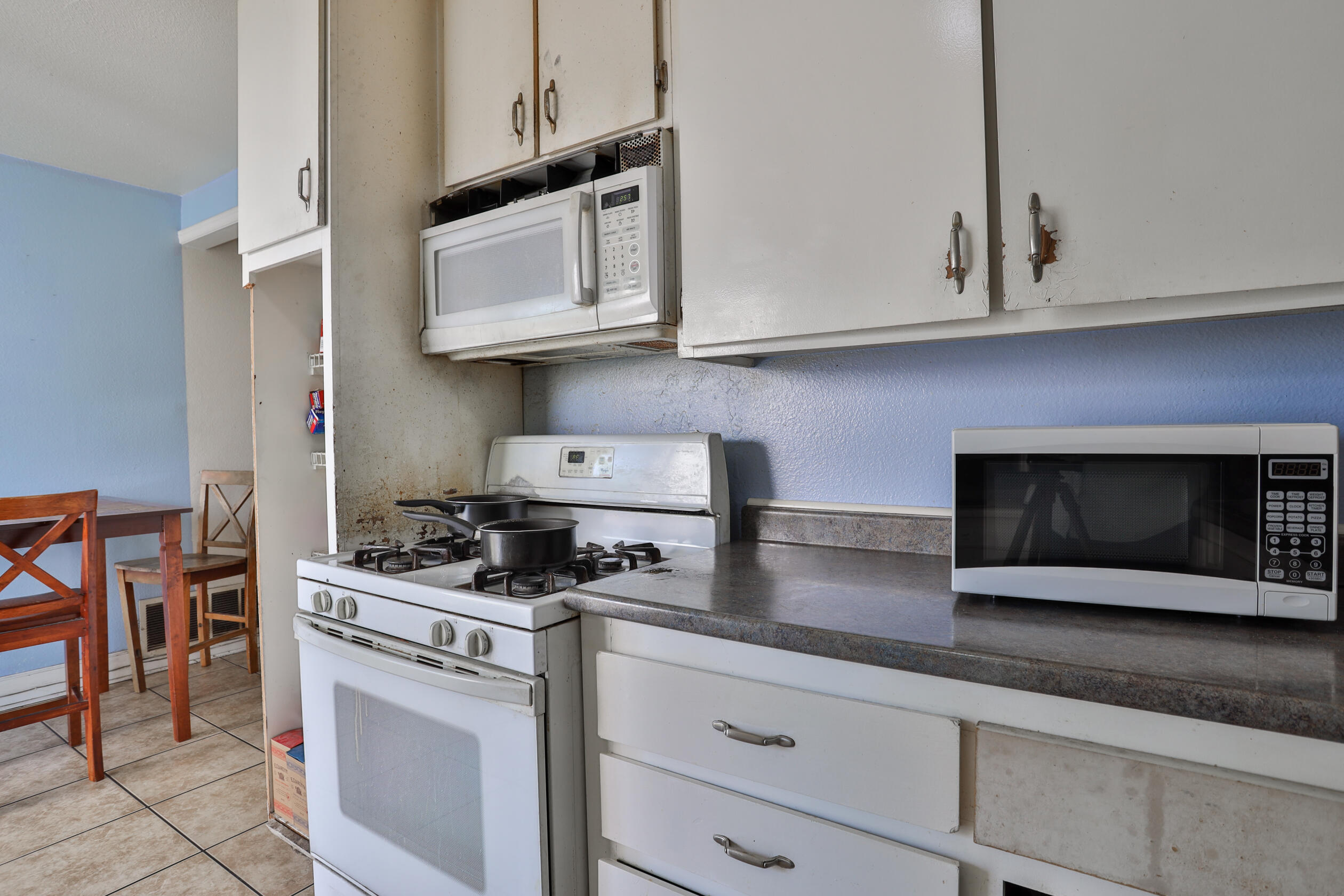 464 Riverside Avenue Rialto, CA 92376 - Photo 26 of 33 a kitchen with stainless steel appliances granite countertop white cabinets stove and granite counter top
