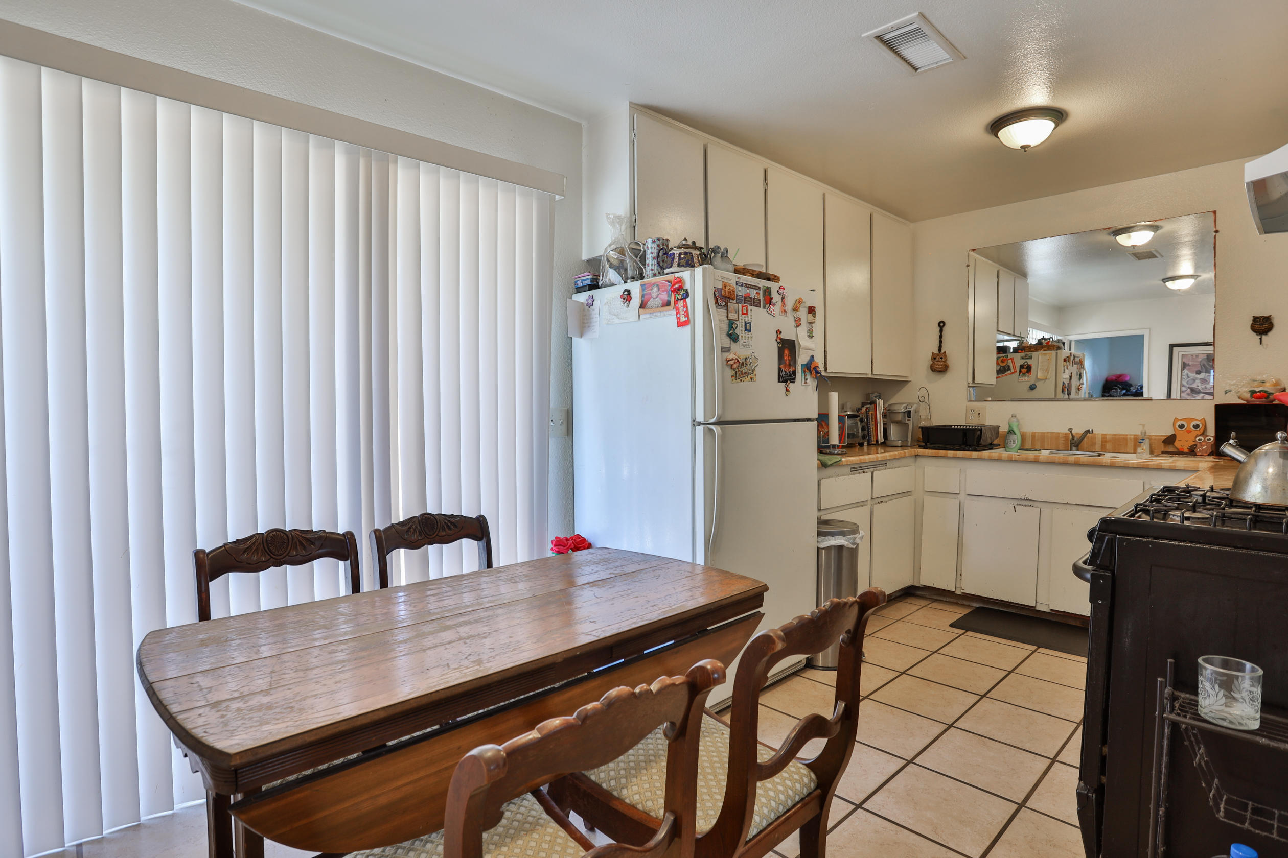464 Riverside Avenue Rialto, CA 92376 - Photo 8 of 33 a kitchen with a table chairs refrigerator and cabinets
