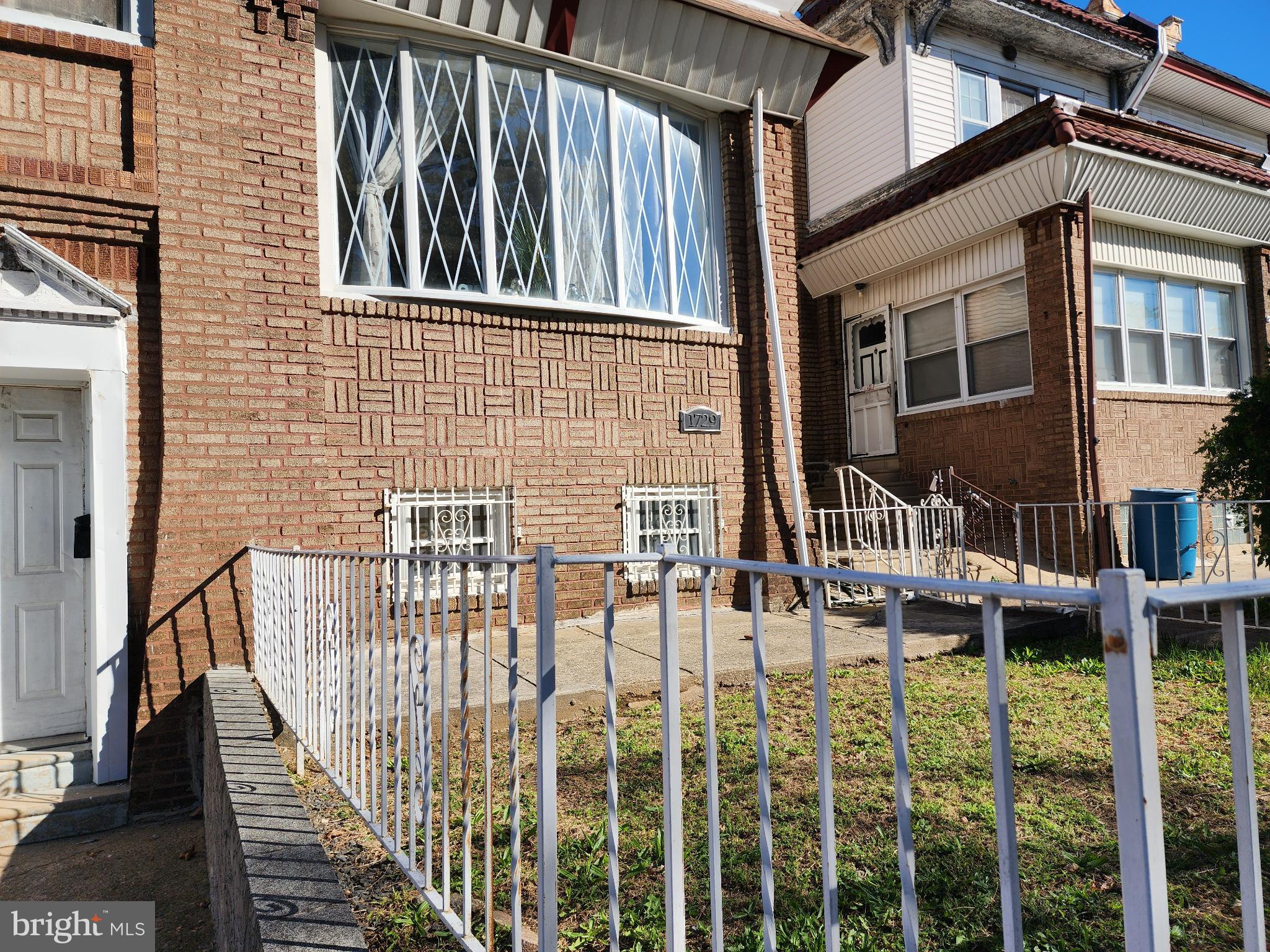 1729 68th Avenue Philadelphia, PA 19126 - Photo 4 of 38 a view of a brick house with large windows and a table