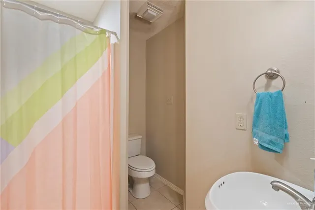 a bathroom with a sink a toilet and shower curtain