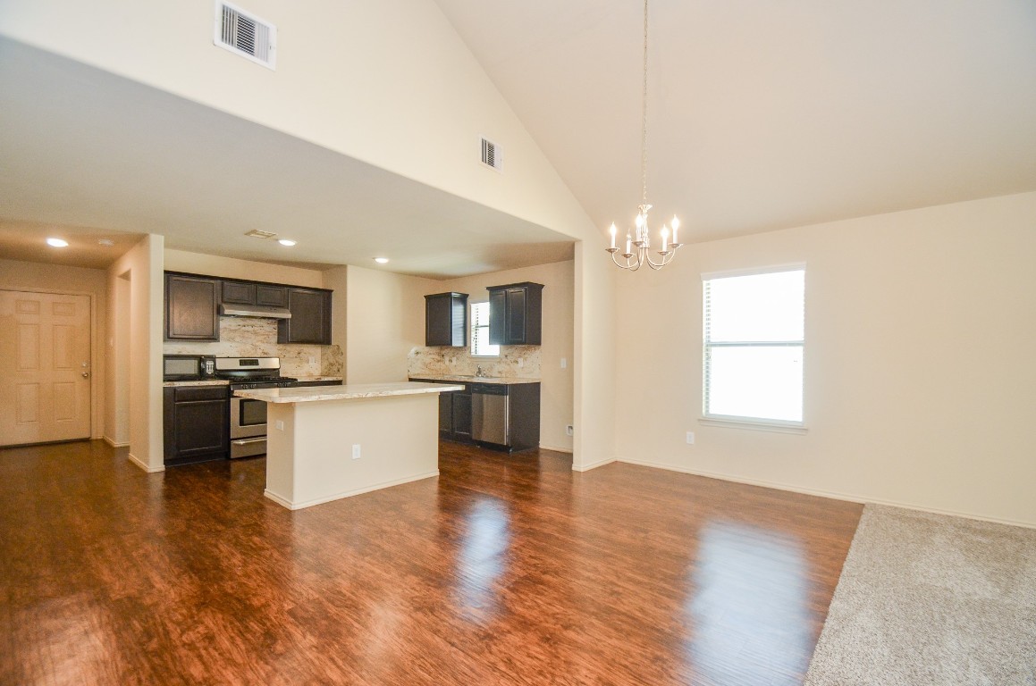 20114 Louetta Ash Drive Spring, TX 77388 - Photo 9 of 32 a large kitchen with kitchen island a sink dishwasher stove and white cabinets with wooden floor