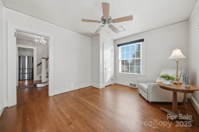 a view of a livingroom with furniture a ceiling fan and wooden floor