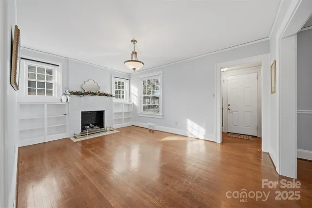 a view of empty room with wooden floor and fireplace