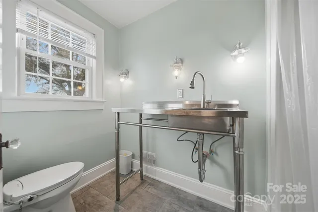 a bathroom with a toilet a sink and a window