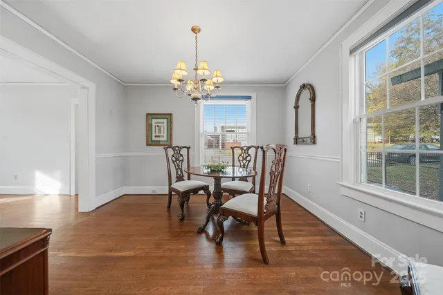 a view of a dining room with furniture a chandelier and wooden floor