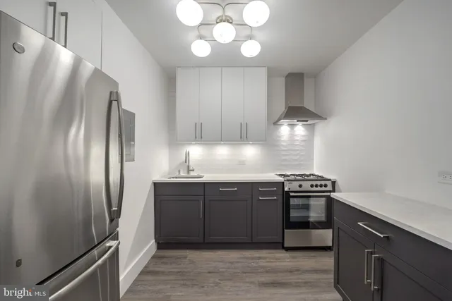 a kitchen with stainless steel appliances granite countertop a refrigerator and a stove