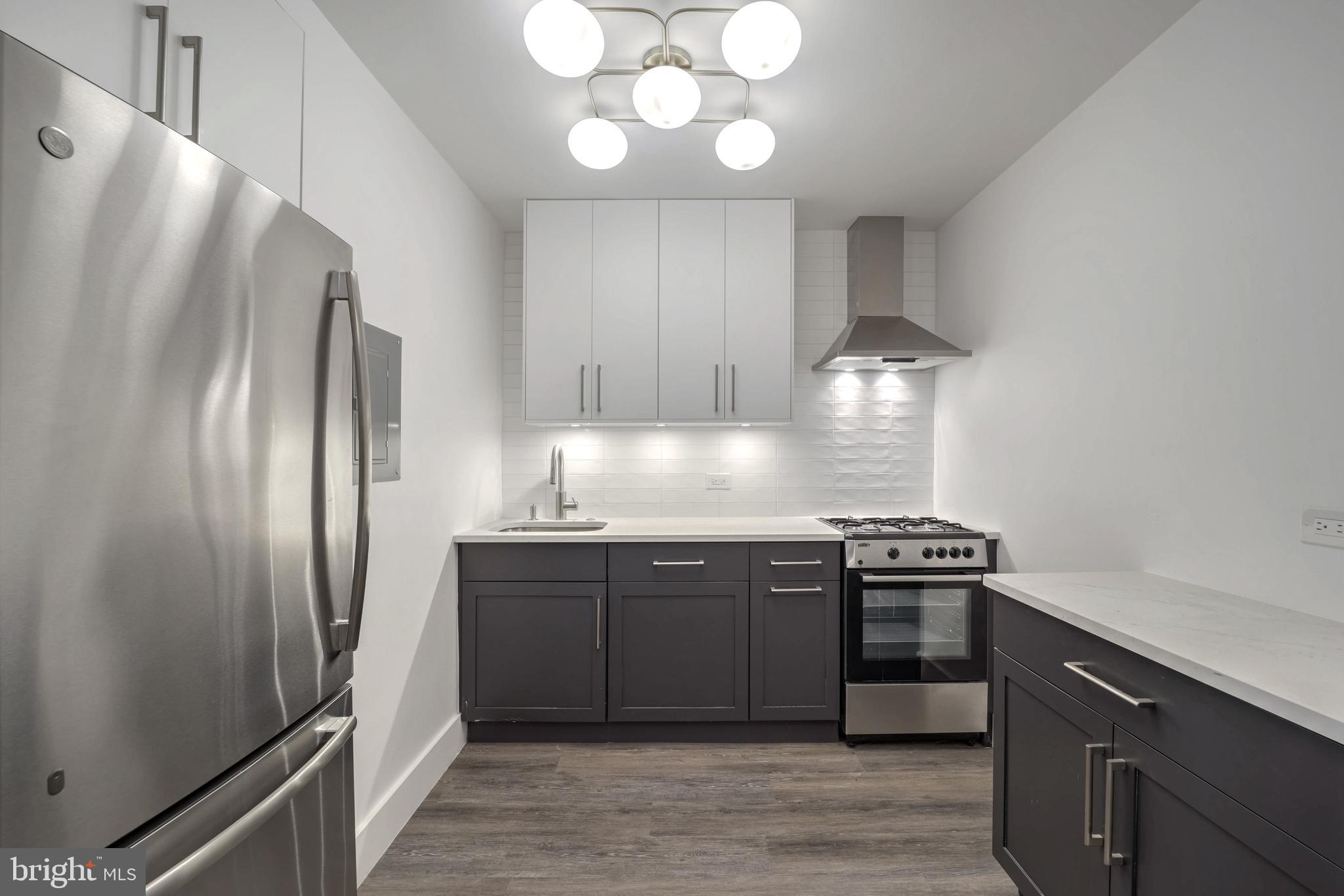 a kitchen with stainless steel appliances granite countertop a refrigerator and a stove