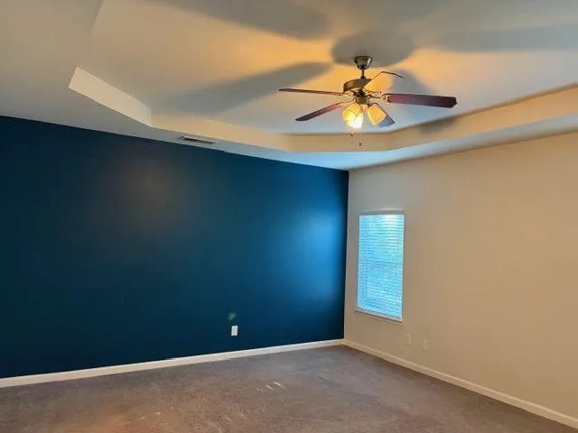 an empty room with closet and fan