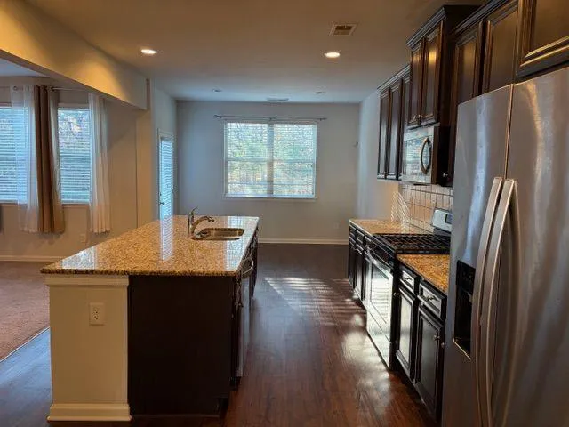 a kitchen with granite countertop wooden cabinets a stove top oven and granite counter tops