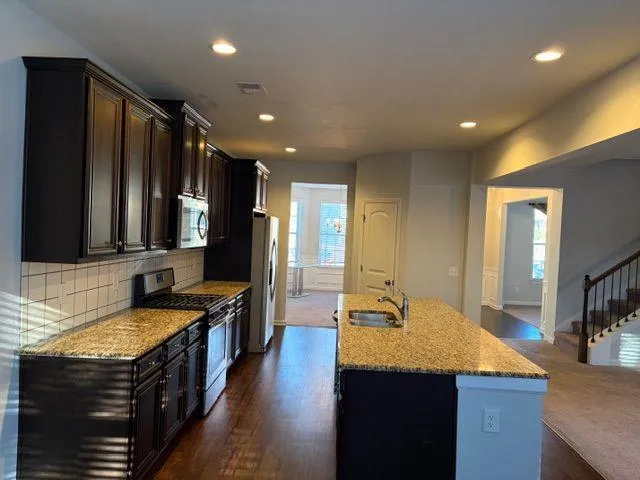 a view of an empty room with chandelier fan and fire place