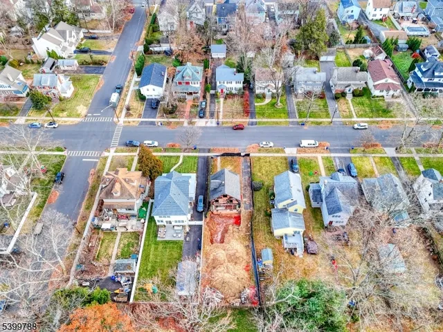 an aerial view of residential houses with outdoor space and parking