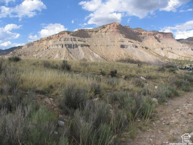 700 Spring Canyon Road Helper, UT 84526 - Photo 2 of 19 Expansive natural landscape featuring a prominent mountain backdrop, diverse natural vegetation, and a clear blue sky with clouds