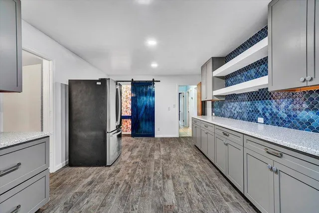 a kitchen with stainless steel appliances granite countertop a refrigerator and a sink
