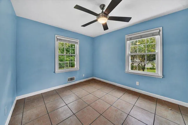 a view of an empty room with window and cabinet