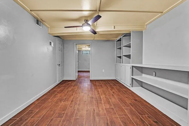 a view of empty room with wooden floor