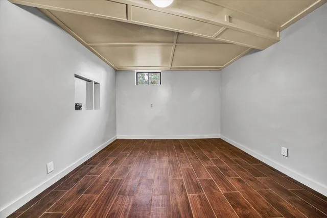 a view of empty room with wooden floor