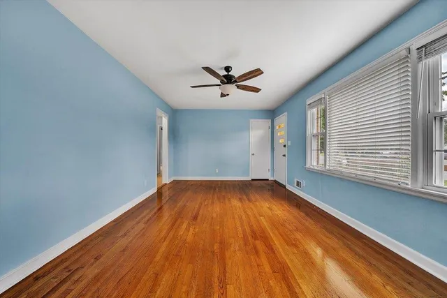 wooden floor in an empty room with a window