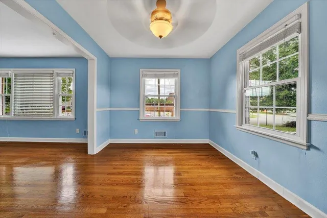 a view of a room with wooden floor and windows