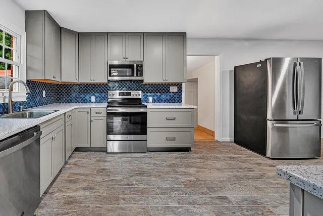 a kitchen with stainless steel appliances granite countertop a refrigerator and a stove