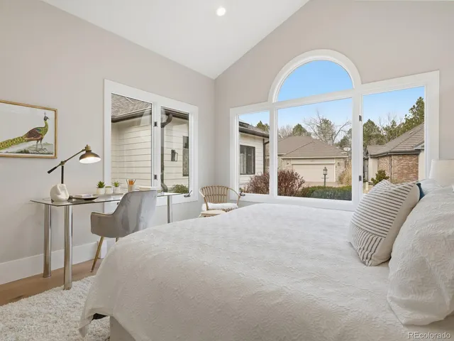 a bedroom with a bed a table and painting on the wall