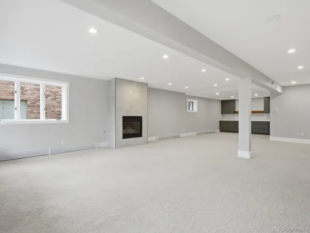 an empty room with a kitchen and windows