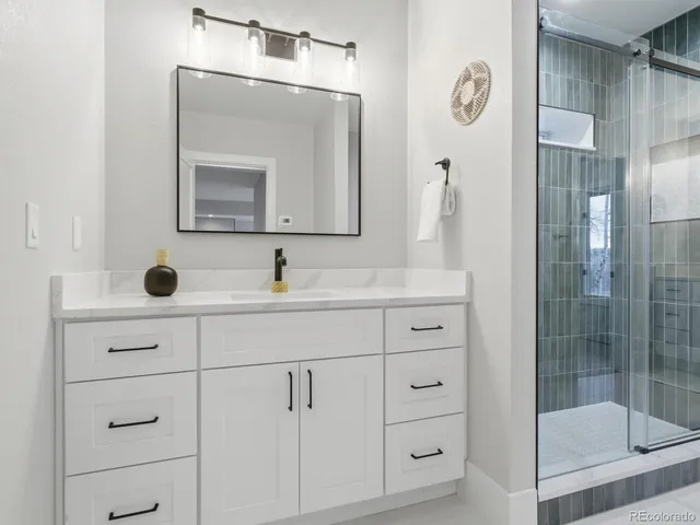 a bathroom with a shower sink and mirror