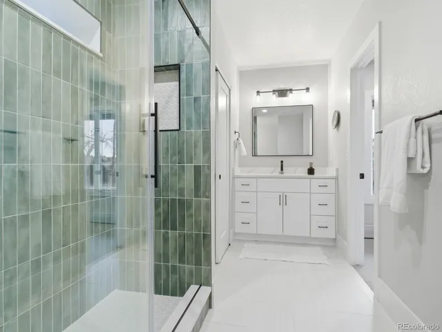 a bathroom with a shower sink and mirror