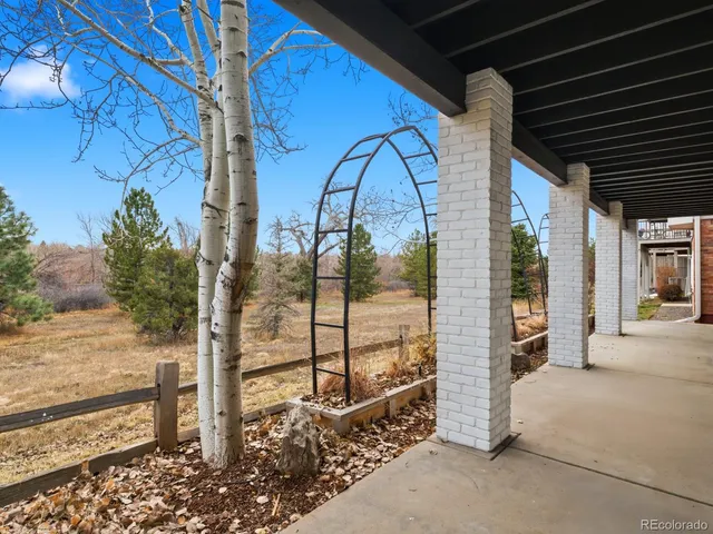 a view of a porch with a floor to ceiling window and tree