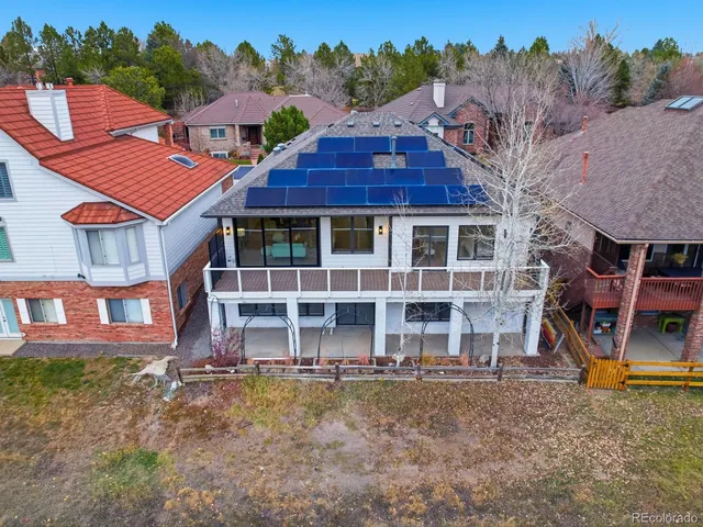 a view of a house with a yard and a large tree