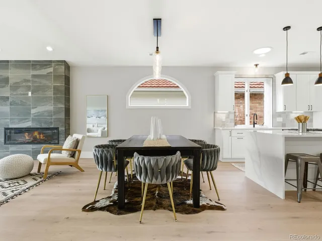 a dining room with furniture a chandelier and wooden floor