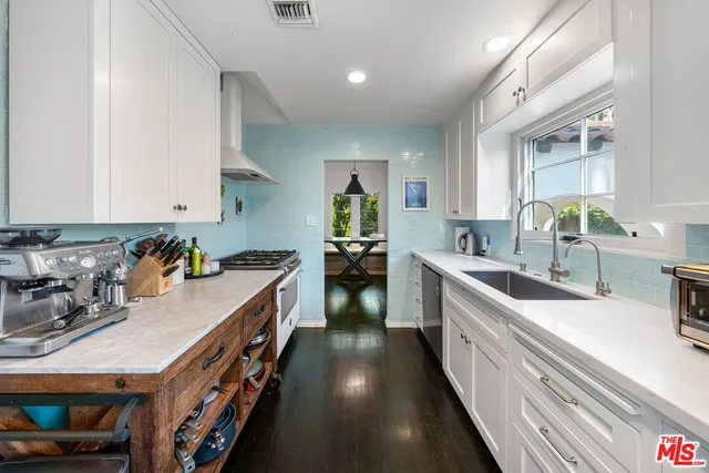 a kitchen with a stove and a white wooden cabinets