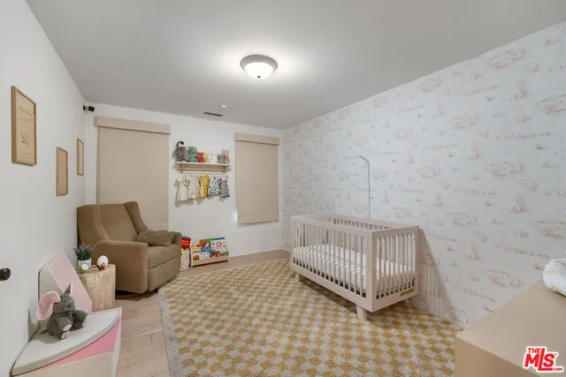 a bedroom with furniture and baby crib