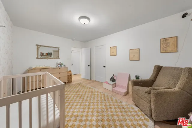 a living room with furniture and baby crib