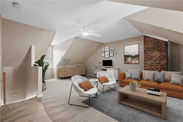 a living room with furniture kitchen view and a window