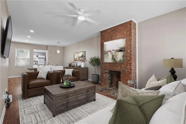 a living room with furniture a fireplace and a large mirror with wooden floor