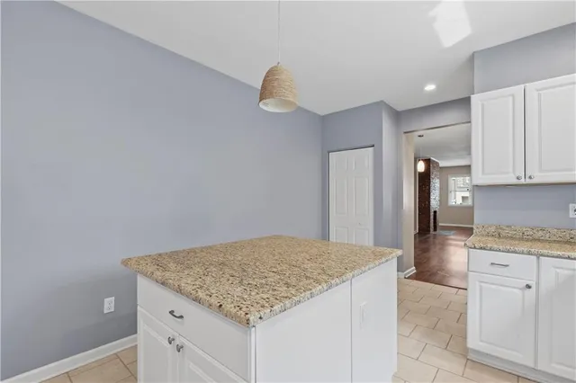 a kitchen with cabinets and chandelier