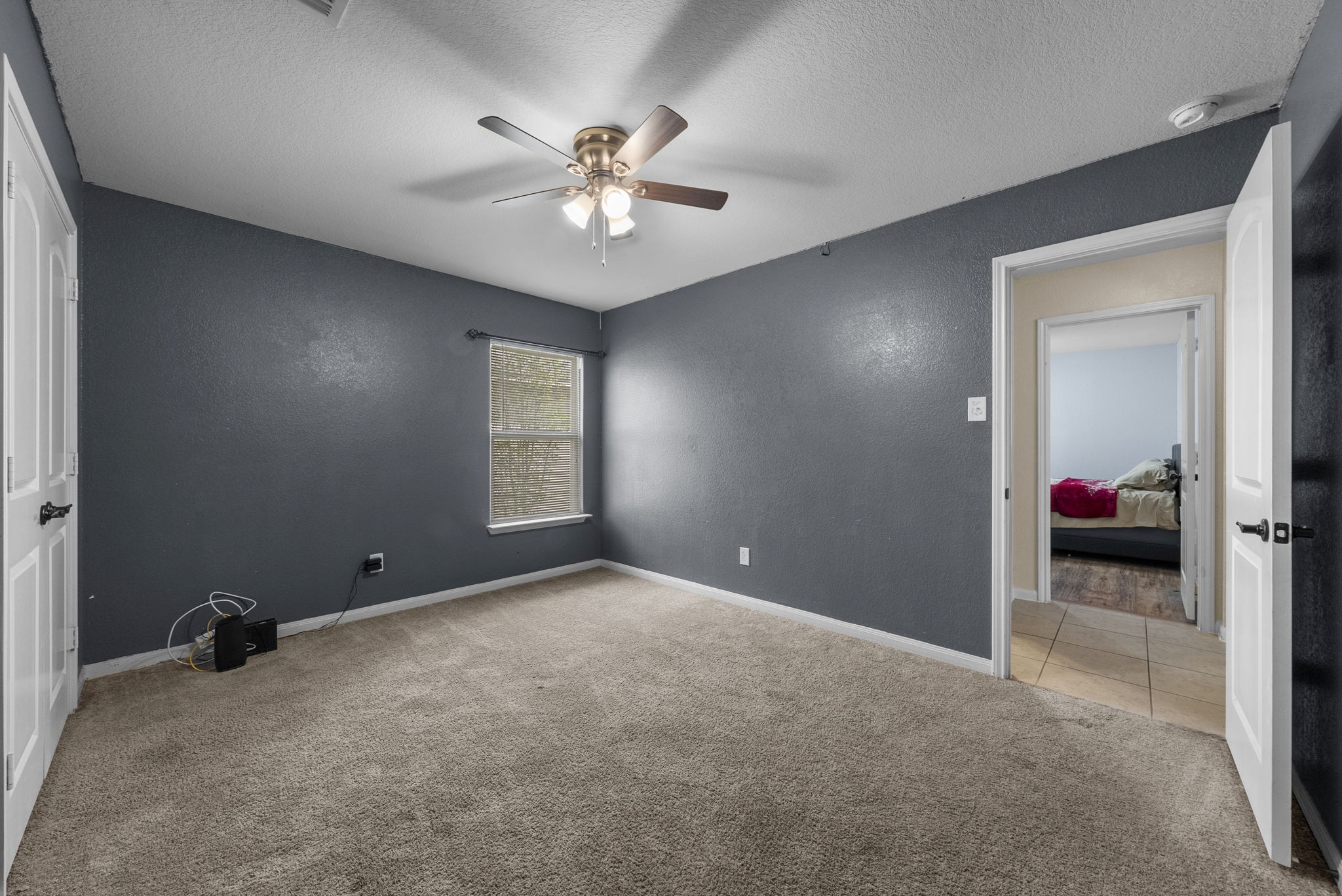 1617 Treeta Trail Kyle, TX 78640 - Photo 20 of 39 Unfurnished bedroom featuring light colored carpet, ceiling fan, a textured ceiling, and a textured wall