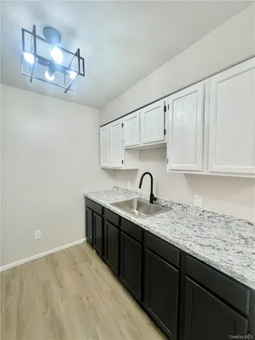 a kitchen with granite countertop a sink and cabinets