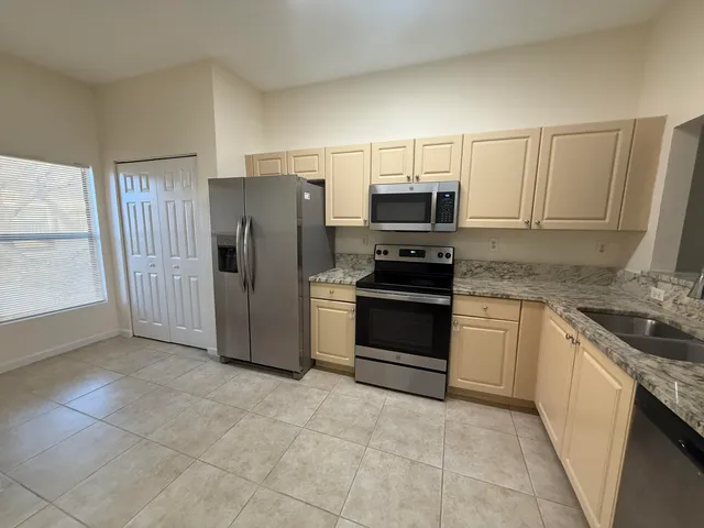 a kitchen with stainless steel appliances granite countertop a refrigerator stove and sink
