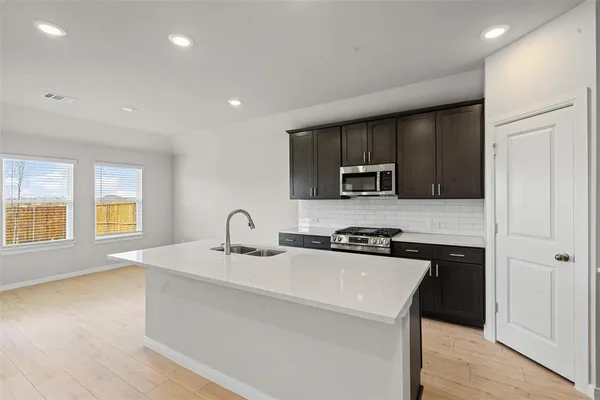 a kitchen with a sink a stove and cabinets