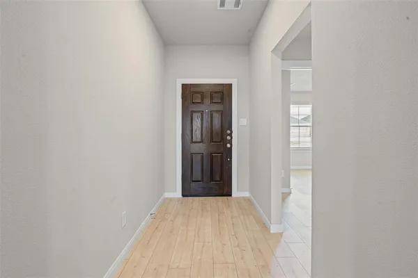 a view of a hallway with wooden floor