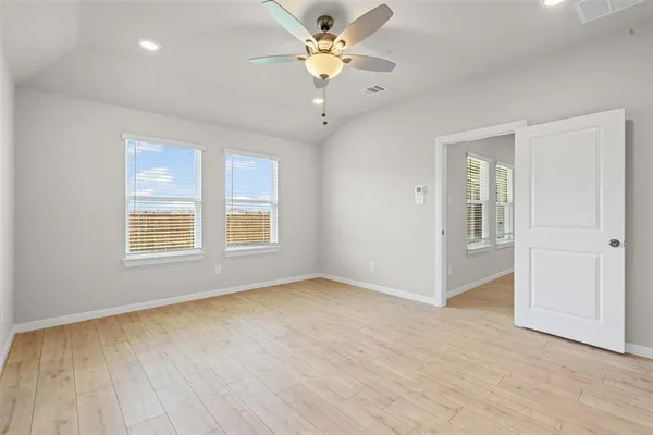 a view of an empty room with a window and a ceiling fan
