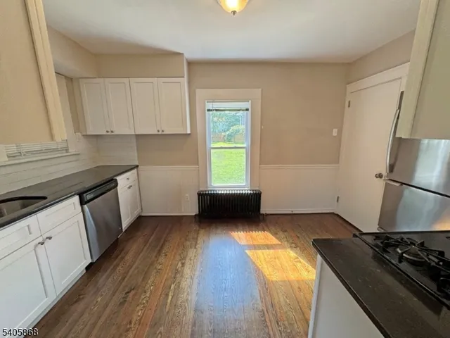 a kitchen with a sink a refrigerator a stove and white cabinets