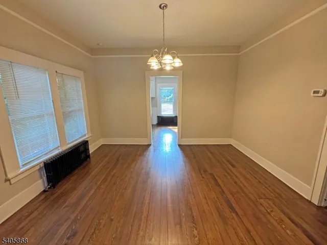 a view of a room with wooden floor and chandelier