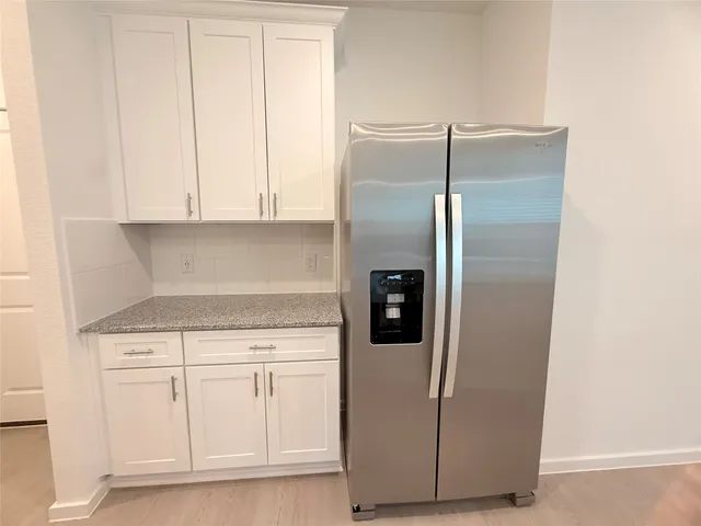 a kitchen with white cabinets and white appliances