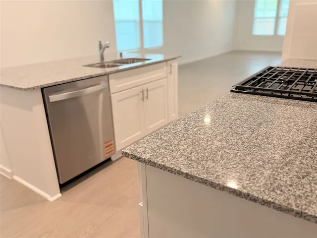 a kitchen with granite countertop white cabinets and white appliances