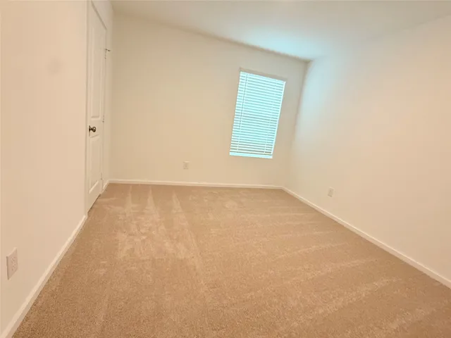 a view of a room with wooden floor and a ceiling fan