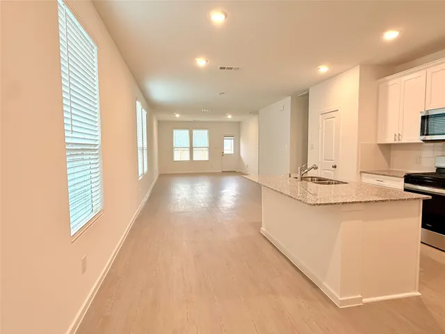 a view of kitchen with kitchen island and stainless steel appliances