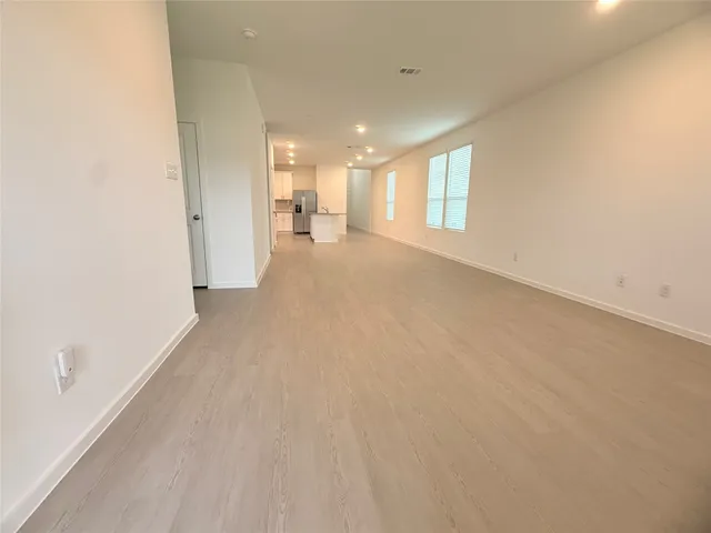 a view of a hallway with wooden floor and a large window