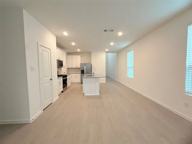 a view of kitchen with center island stainless steel appliances refrigerator sink and cabinets